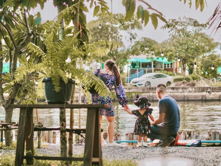 a group of people standing around a body of water